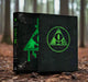 Black book with green symbols on a forest floor