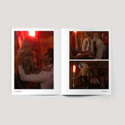 Open book showing a romantic scene with two people in a dimly lit room.